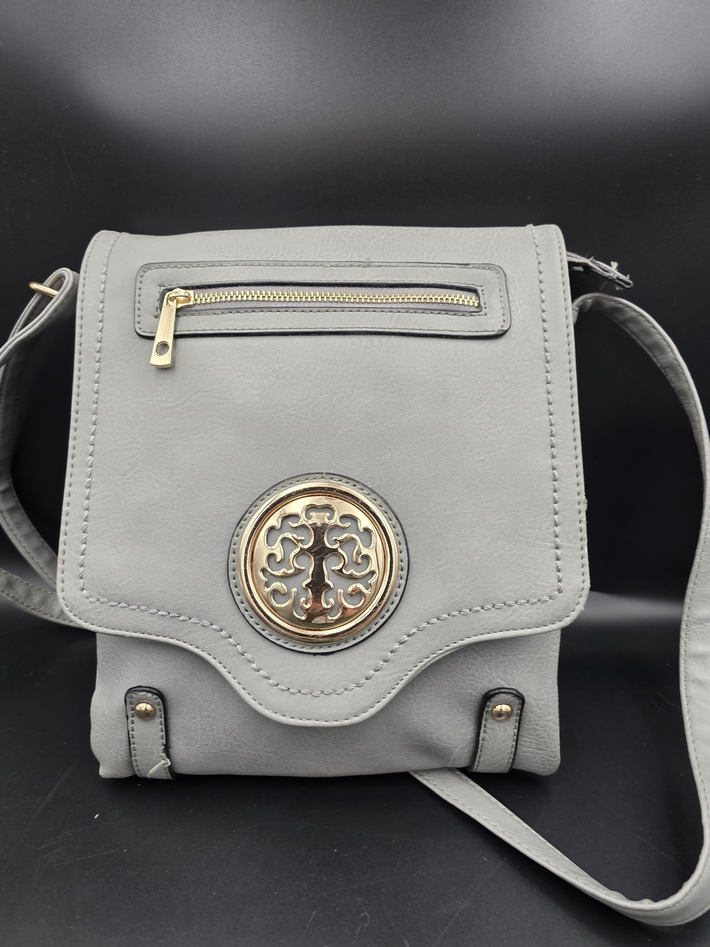 Gray Crossbody Bag with Decorative Gold Emblem